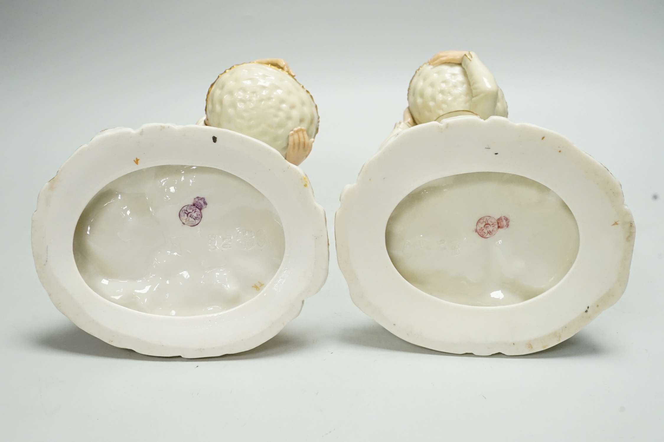 A pair of Worcester porcelain figures, modelled as a boy and girl with baskets, shape number 880, 26cm